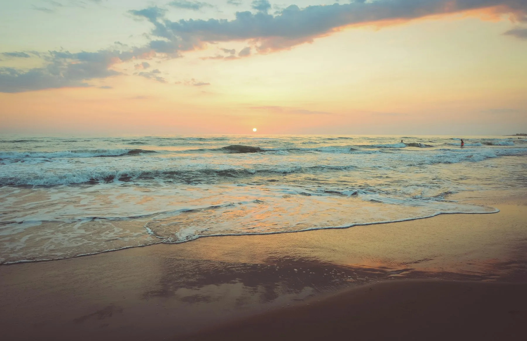 Gentle waves on a beach at sunset
