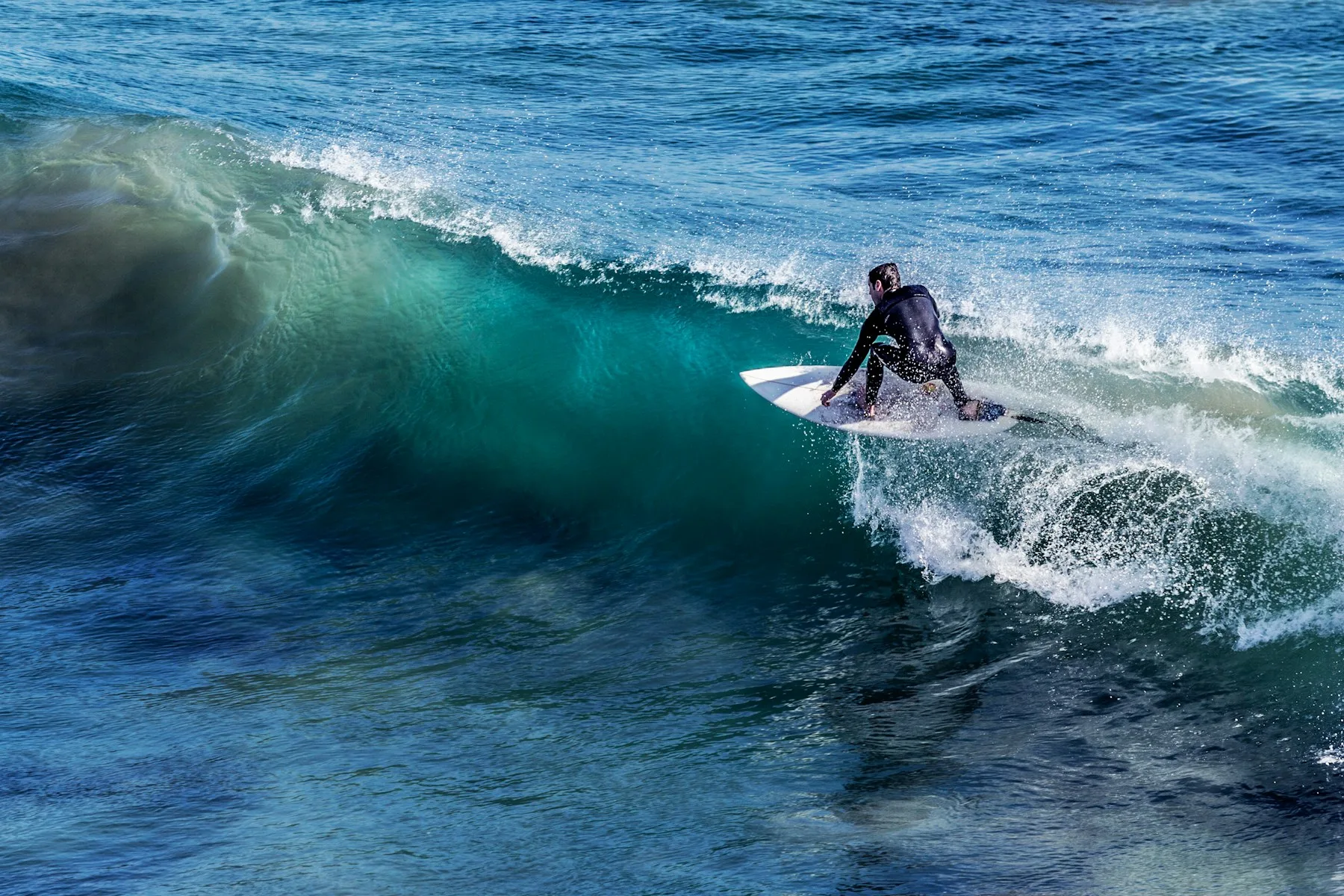 Surfer carving across a breaking ocean wave